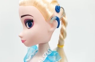 Foto da cabeça da boneca Elsa, da animação Frozen, que um implante coclear.